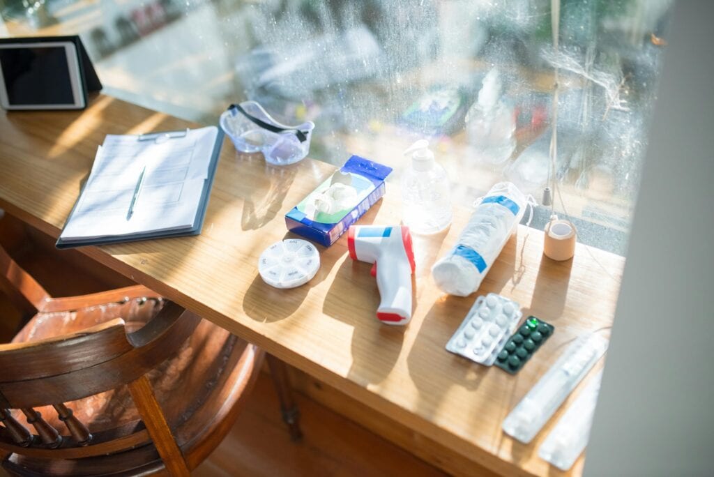 Verschiedene Materialien aus Verbandskästen liegen ausgebreitet auf einem Tisch.