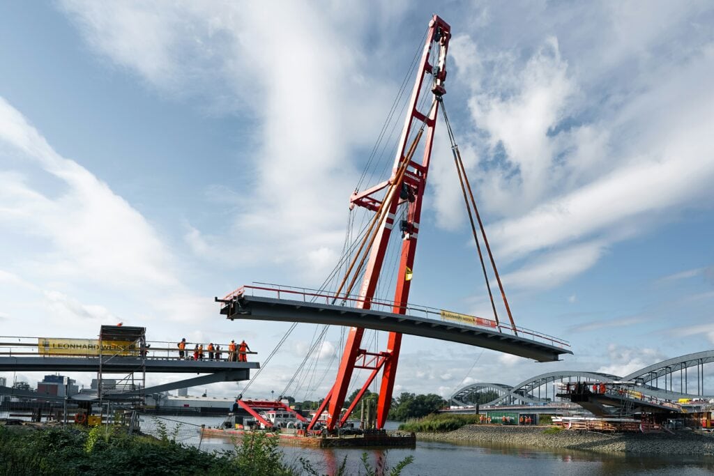 Ein Brückenbauteil wird mit einem Kran angehoben.